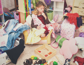 Girl in very messy room. Feature image for How to Start Decluttering when you're Overwhelmed.