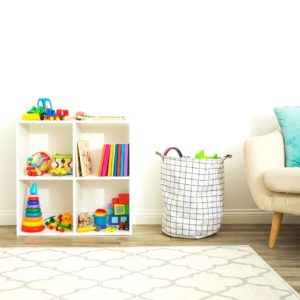 Small organization tube with toys and a toy basket beside it.
