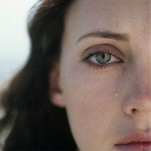 Miscarriage and loss pic of woman's partial face and tear.